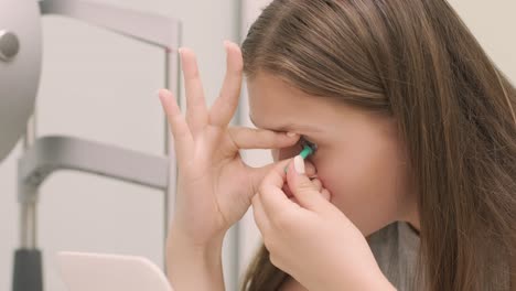 young girl place the contact lens in the front from the mirror with doctor. inserting contact lens. night time contact lenses