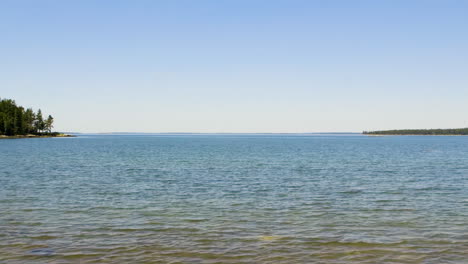 view of clear sky and blue water of the atlantic ocean from a typical northern new england beach during mid summer, late afternoon