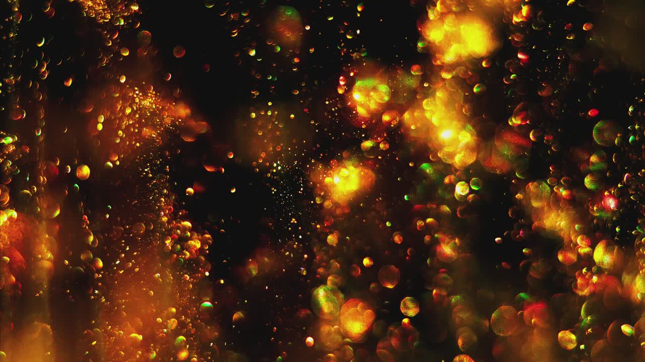 pequeñas bolas de fuego doradas y borrosas brillando, moviéndose lenta y al azar en el fondo del espacio negro.