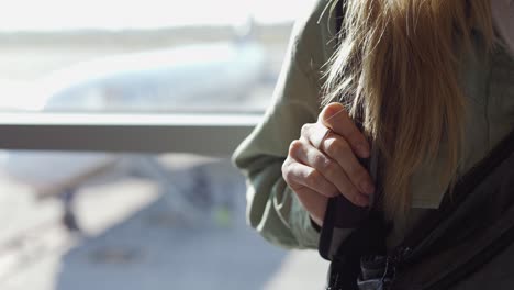 close up of unrecognizable woman with backpack at the airport terminal