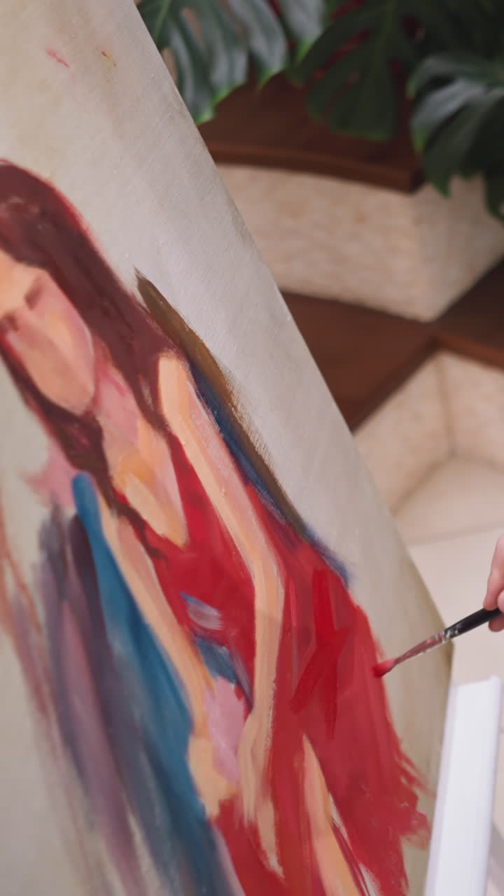 el artista agrega color rojo al vestido en el lienzo. el pintor elige colores y sombras que dictan el estado de ánimo y la atmósfera del retrato en evolución. el pintor intuitivo