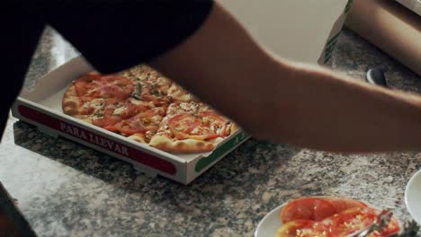 cocinero preparando pizza para la entrega en la cocina