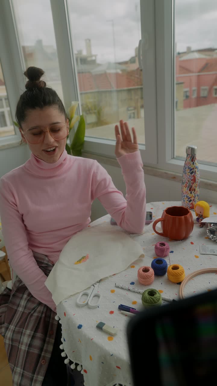 Young Woman Explaining Embroidery Techniques in a Home Setting