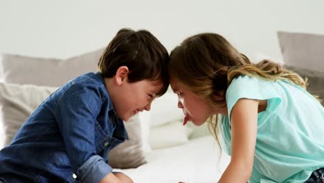 Two-children-having-fun-on-bed-in-bedroom