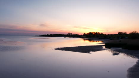 aerial flyover water of baltic sea during golden sunset on hel island,poland