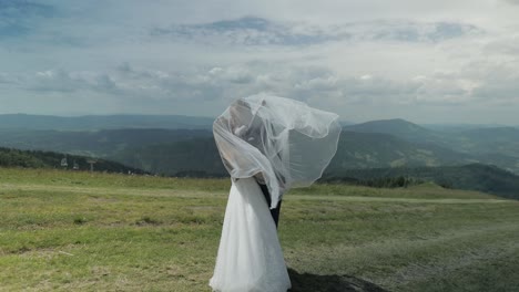 romantic wedding couple kissing on mountaintop