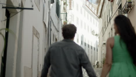 Beautiful-multiracial-couple-walking-along-cobble-stone-road.