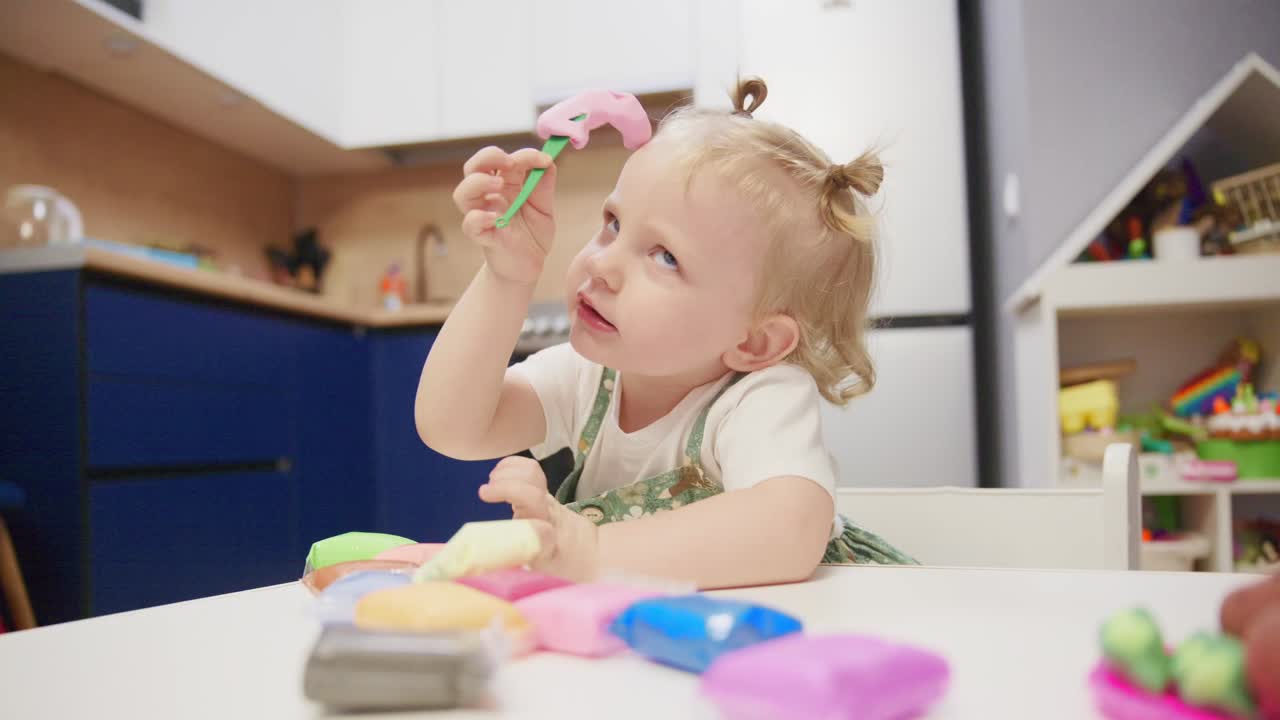 Cute Toddler Girl Playing with Colorful Modeling Clay at Home