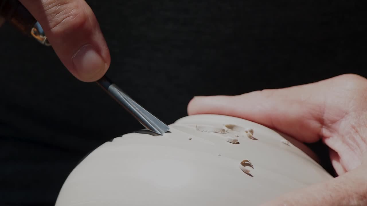 세라믹 꽃병에 칼로 조각하는 마스터 포터