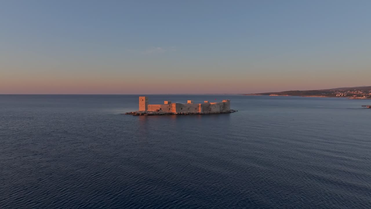 Alba sul Castello della Fanciulla che si affaccia su un mare sereno a Kizkalesi