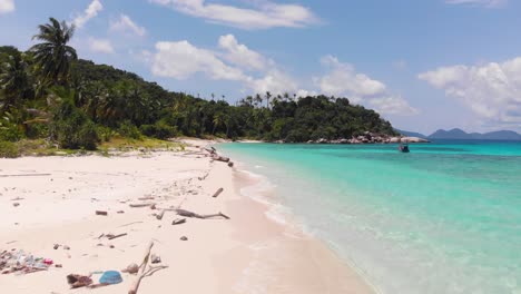 basura y madera a la deriva en una hermosa playa tropical con aguas turquesas cristalinas, toma aérea de drones del arrecife de la playa de la isla paraíso