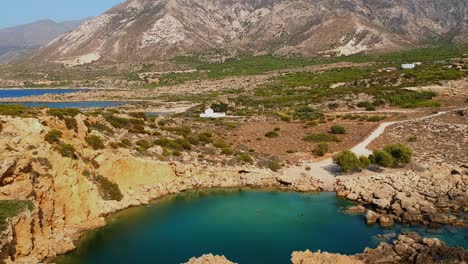 impresionante vista aérea de un pequeño cráter marino rodeado de rocas, formando un pequeño lago marino