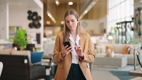 blonde customer strolls showroom, smiles at smartphone then scans products
