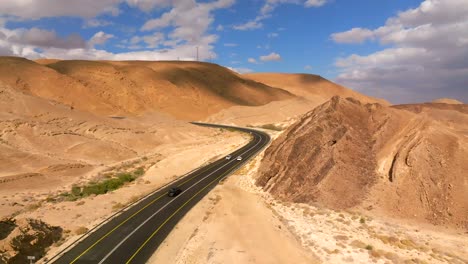 Car-zooming-by-heading-north-on-a-Desert-highway-with-cloudy-blue-sky