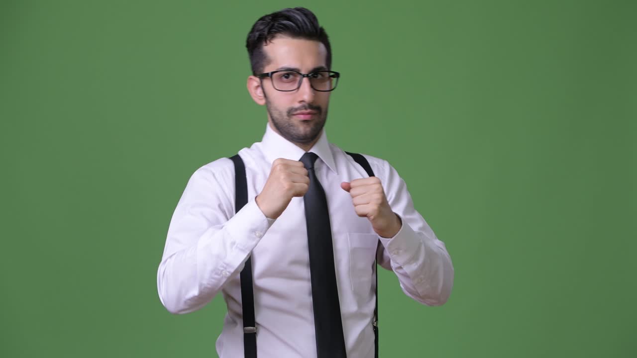 joven empresario persa barbudo y guapo contra un fondo verde