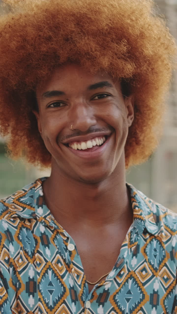 Ritratto ravvicinato di un giovane felice con capelli afro, sorridente