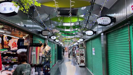 a quiet market alley with colorful shops and a single person walking down the aisle