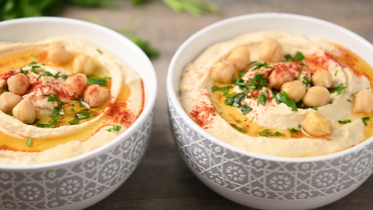 Video di hummus di ceci con olio d'oliva, prezzemolo e paprika in ciotola