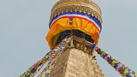 Close-up-panning-clip-of-brightly-coloured-prayer-flags-and-ornate-golden-Buddhist-temple-in-Kathmandu,-Nepal