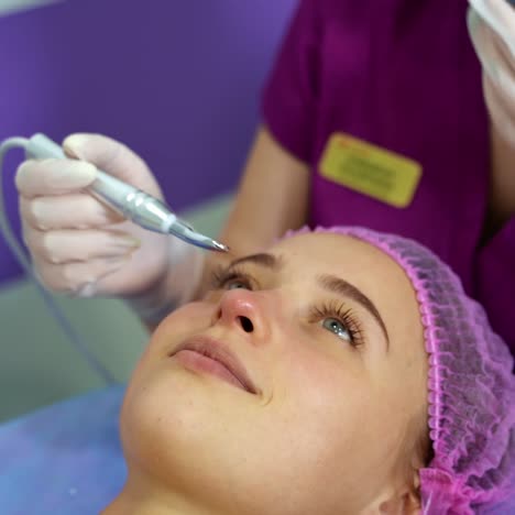 beautician provides beauty manipulations with client`s face. anti aging procedures. beauty clinic