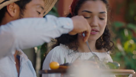 Pareja-Feliz-Celebrando-En-Una-Cena-Con-Amigos-Comiendo-Comida-Mediterránea-Compartiendo-Un-Plato-Sentados-En-La-Mesa-Disfrutando-De-Un-Festín-Con-Imágenes-De-4k