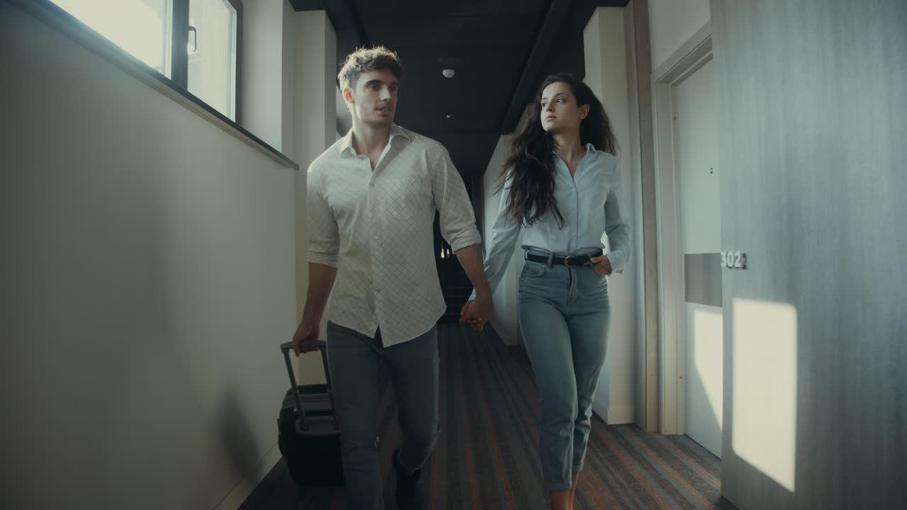 웃는 부부는 호텔 방을 찾고 있습니다.