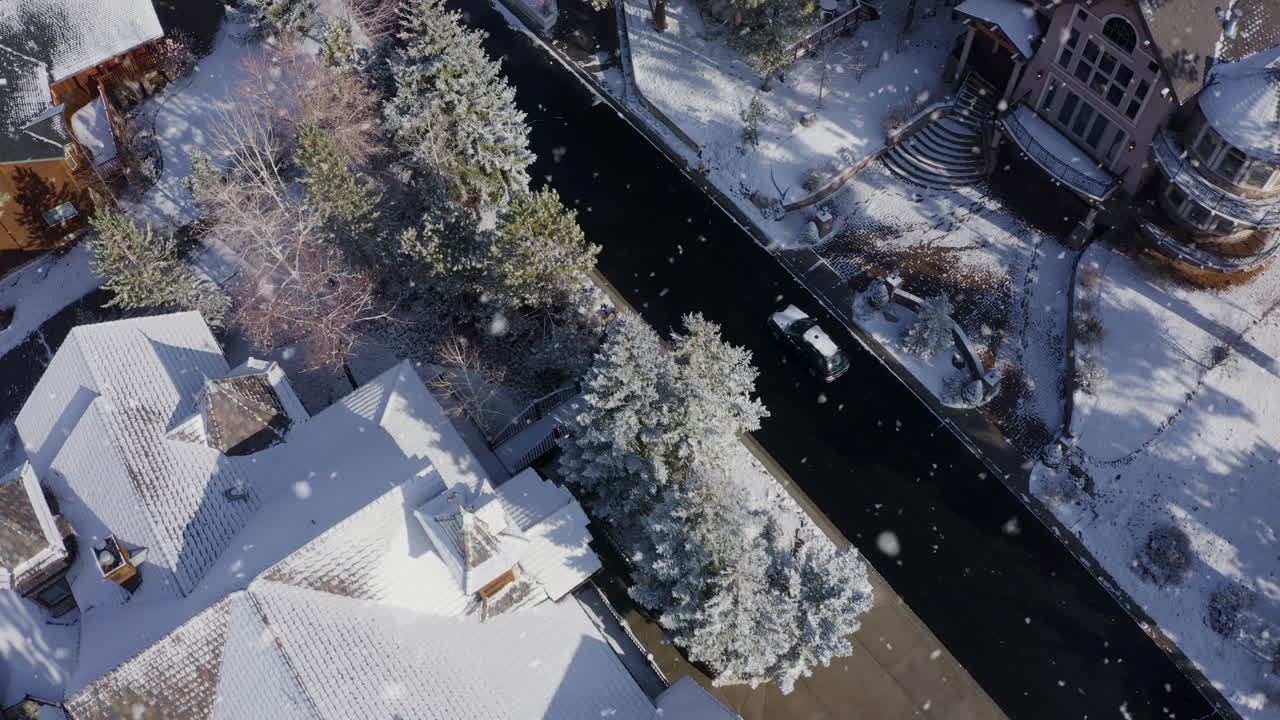 눈이 내리면 눈 덮인 자동차가 놀라운 부유한 게이트 커뮤니티를 통과합니다.