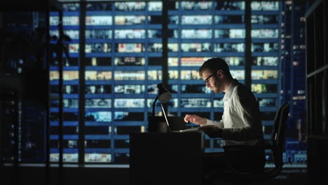 Portrait-of-Thoughtful-Successful-Businessman-Working-on-Laptop-Computer-in-His-Big-City-Office-at-Night.-Charismatic-Digital-Entrepreneur-does-Data-Analysis-for-e-Commerce-Strategy