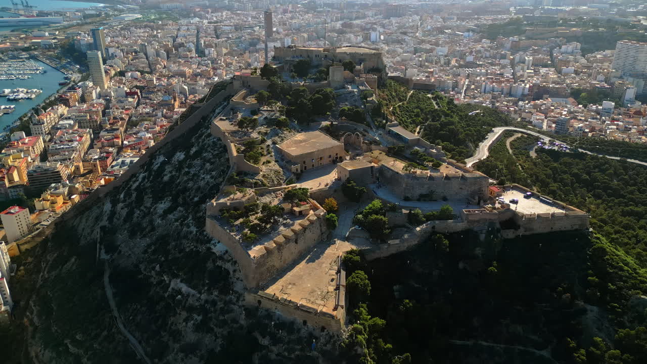 Aerial drone view of the Santa Barbara Castle on the coast of Alicante, Spain with the city and the sea on the background