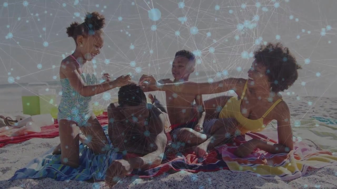 Man lying inviting children touching hair on beach, woman in yellow watching, towels, blue overlay