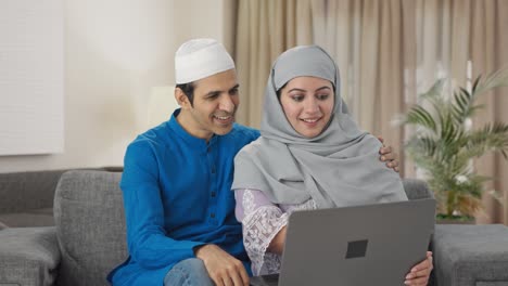 muslim couple doing online shopping on laptop