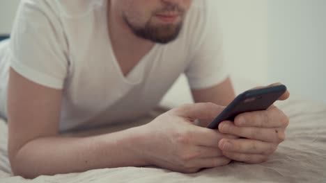close up shot of the man's hands, who chat with friends on the smartphone