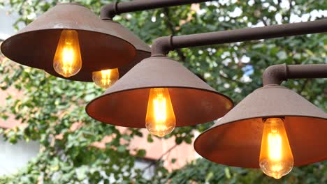 three rustic metal hanging lights with edison bulbs