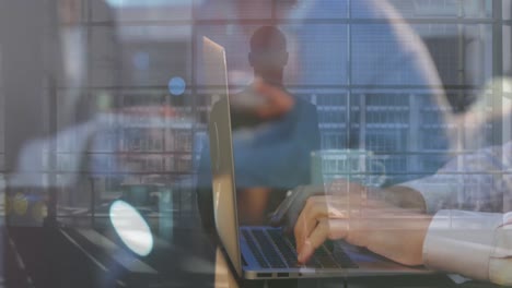 Animation-of-rear-view-of-man-walking-with-trolley-bag,-cropped-hands-of-caucasian-man-using-laptop