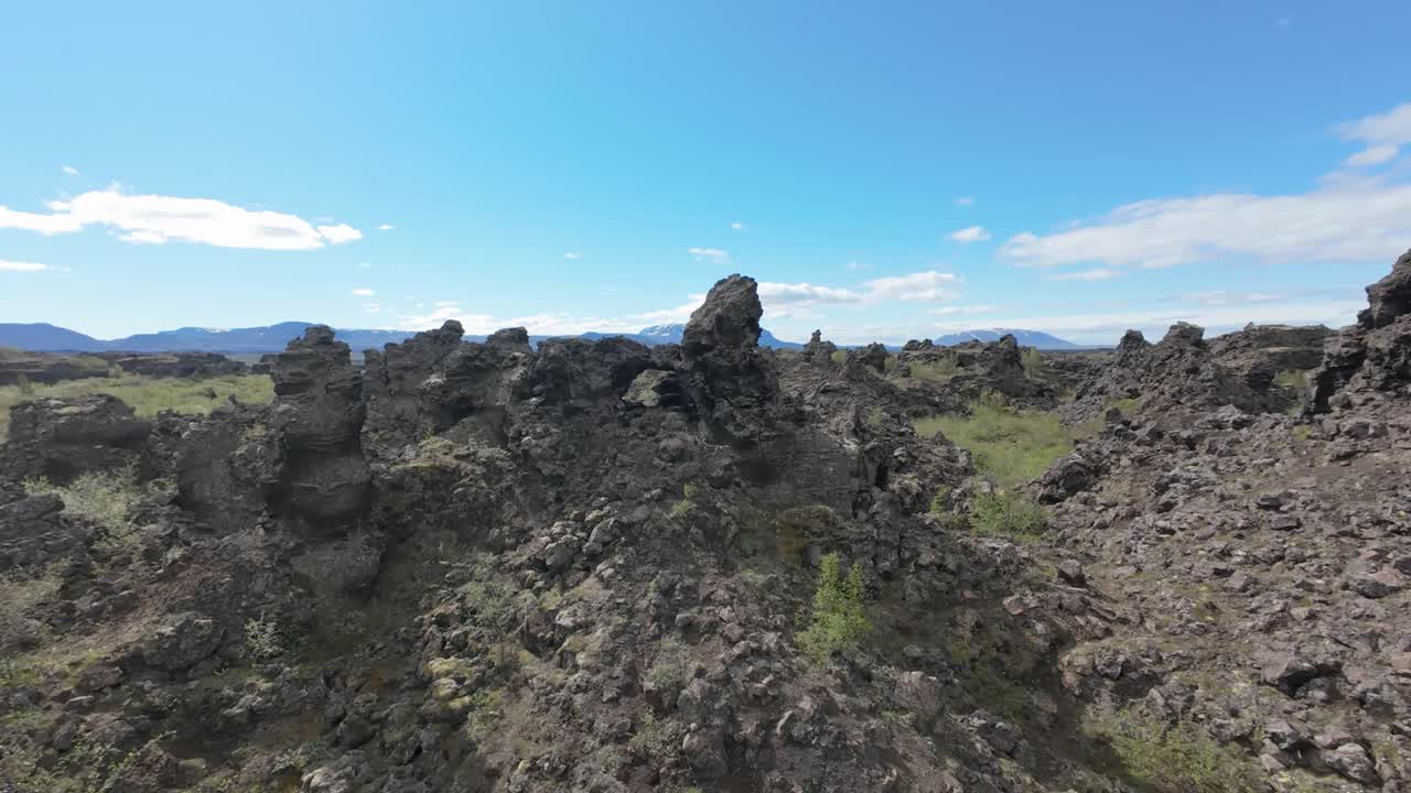FPV-flyvning om sommeren over Islands nordøstlige del: højt over Dimmuborgirs ældgamle lavafelter nær Mývatn-søen, dykker ned gennem et naturligt lavasten-vindue.