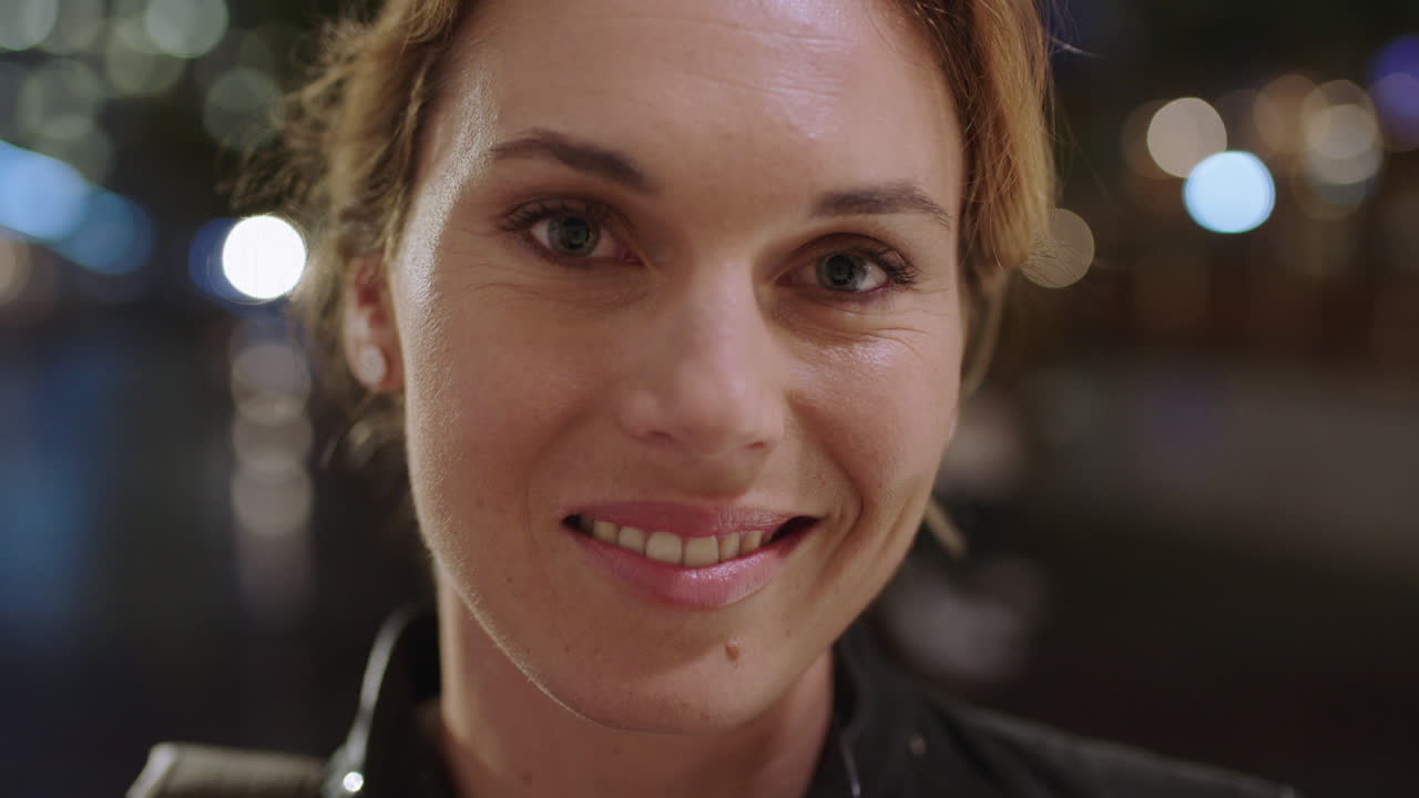 retrato de cerca de una hermosa mujer rubia sonriendo alegremente disfrutando de la noche en la ciudad