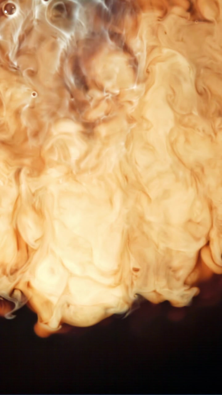 Grädde som blandas i mörkt kaffe i slow motion