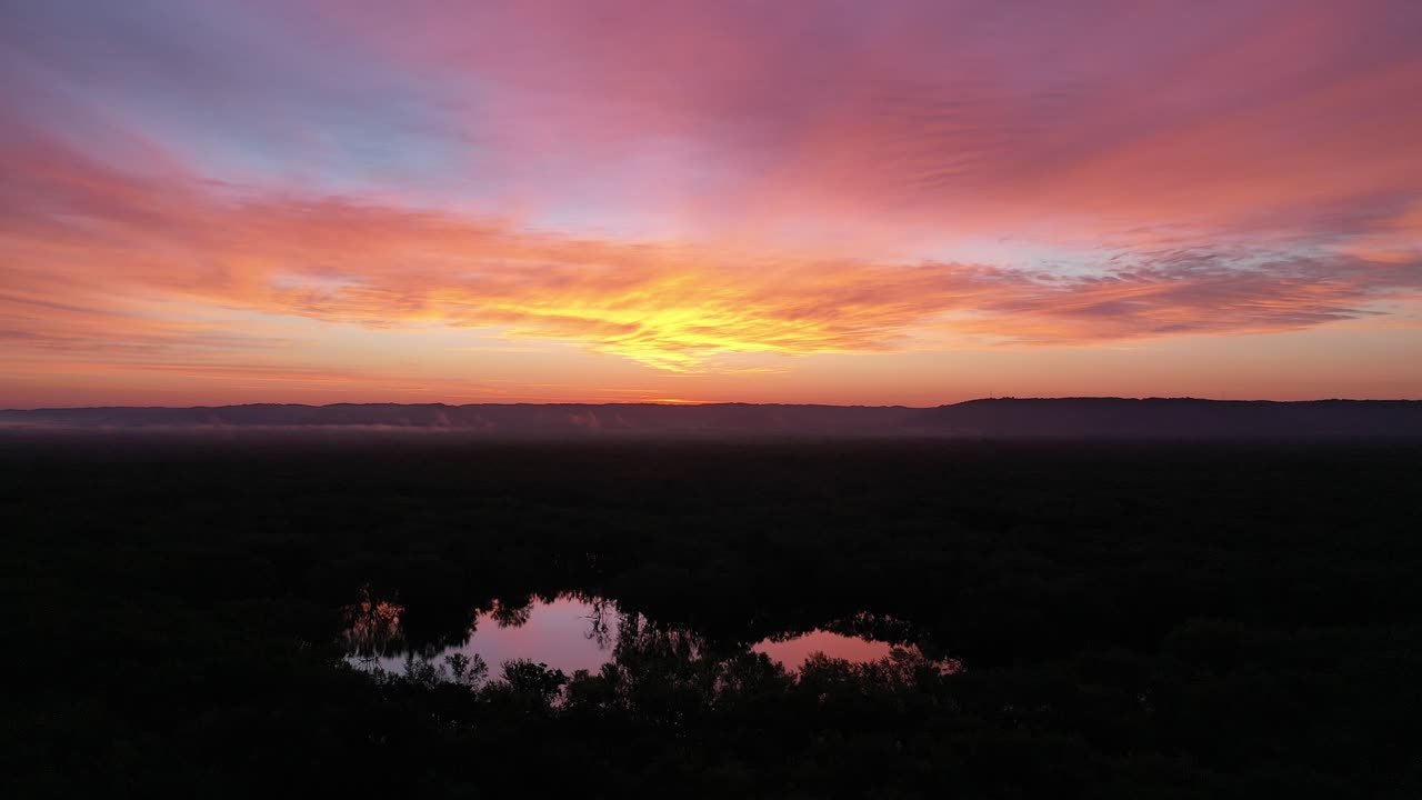amanecer sobre un bosque y un río