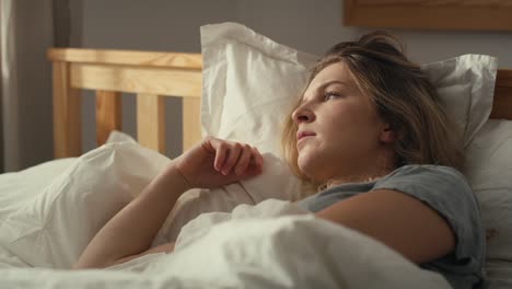 enfoque mujer caucásica acostada en la cama y mirando hacia otro lado