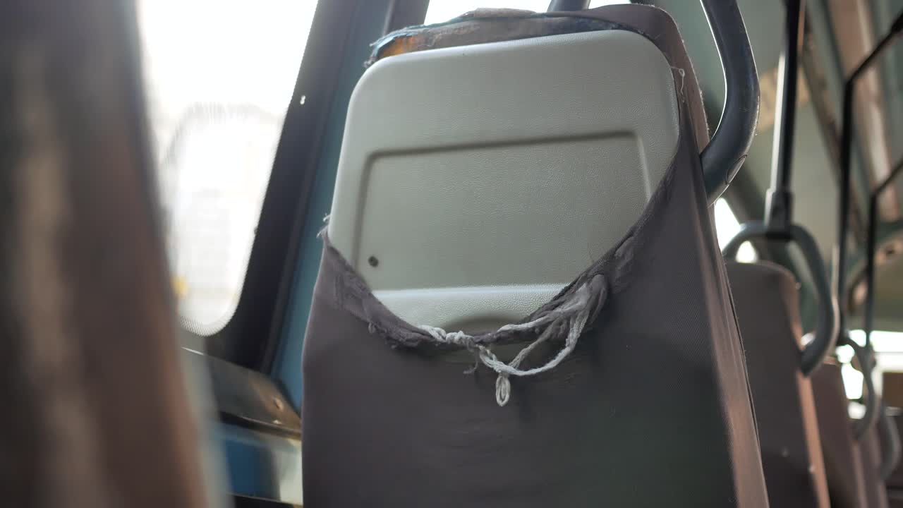 cerca de un asiento de autobús desgastado y rasgado