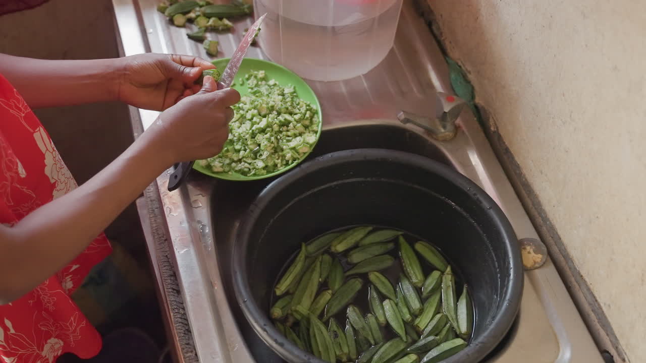 Cooking scene with hands shelling peas into dish. Closeup of hands preparing peas into bowl in kitchen scene. Family member shelling peas into container with gentle motion in morning light