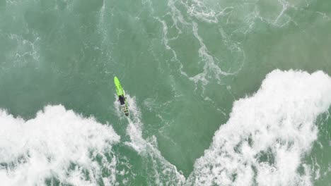 Aerial-drone-shot-of-surfer-catching-a-wave