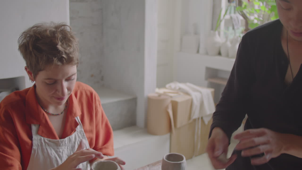 Asian Ceramist Giving Pottery Lesson in Studio