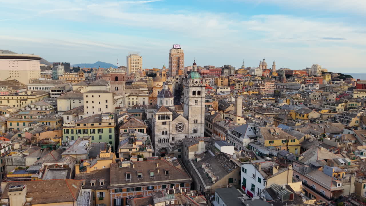Ripresa aerea con carrello del Porto Antico di Genova al tramonto, paesaggio urbano storico italiano, Italia.