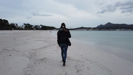 woman walking along a lonely beach in winter