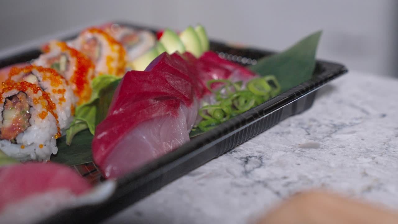 A roaming shot featuring fresh sashimi tuna and sushi rolls, showcasing Japanese cuisine. Perfect for highlighting sushi, sashimi, and food presentation in restaurant menus or culinary promotions.