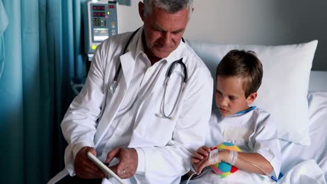 Male-doctor-using-digital-tablet-during-visit-in-ward