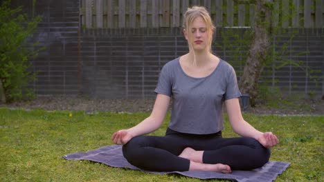 a young woman doing yoga in the backyard