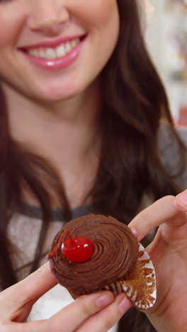 smiling woman holding a cupcake