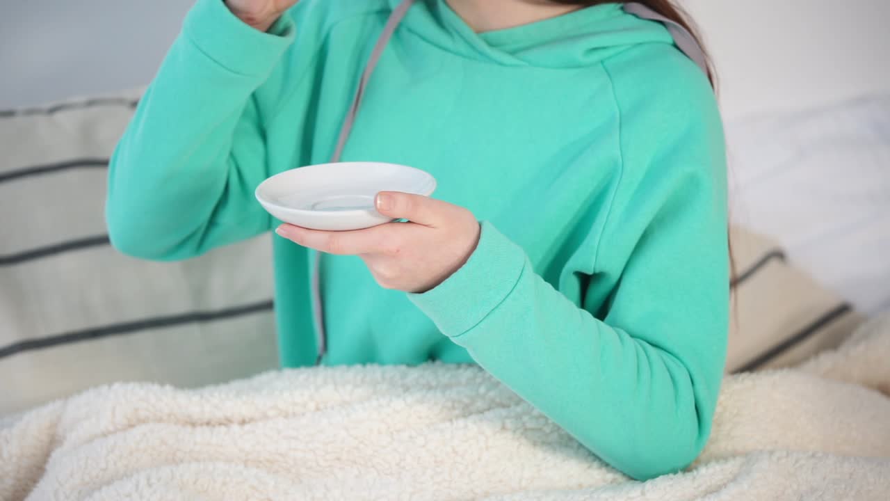 침대에서 음료를 마시는 여자